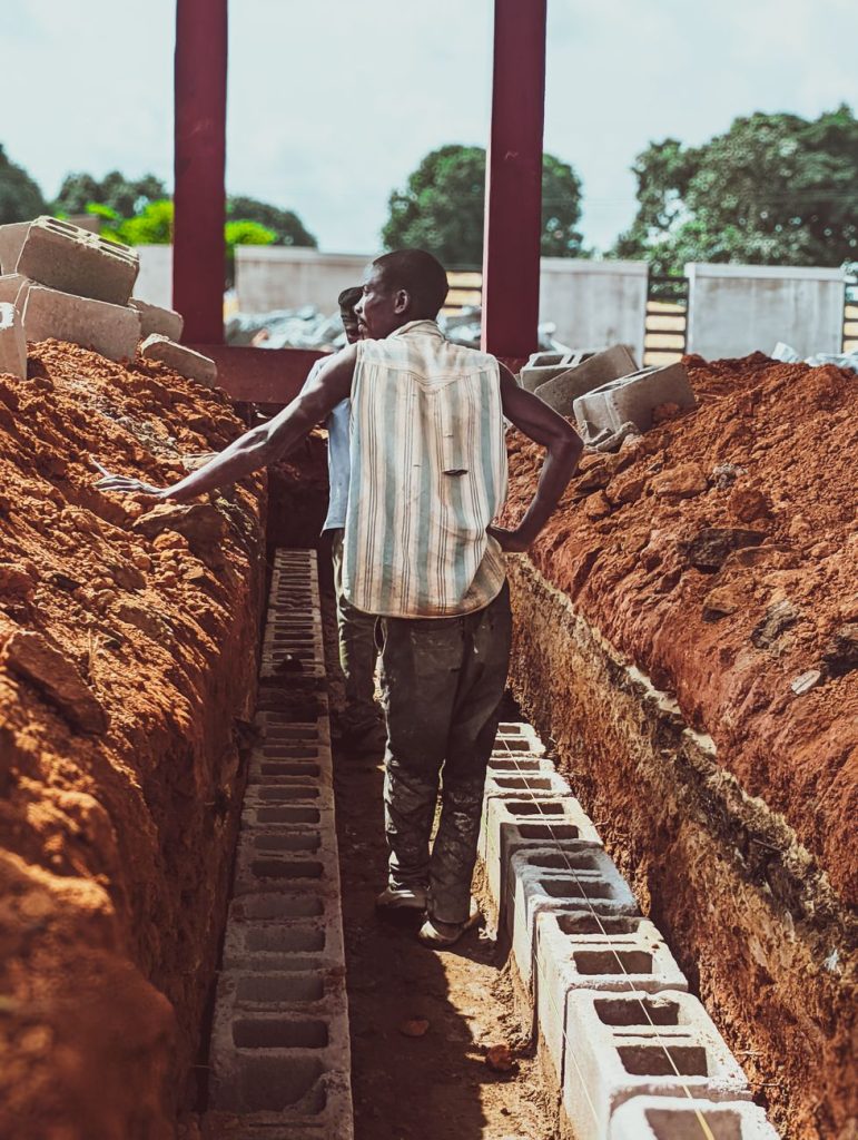 construction workers laying foundation bricks outdoors
