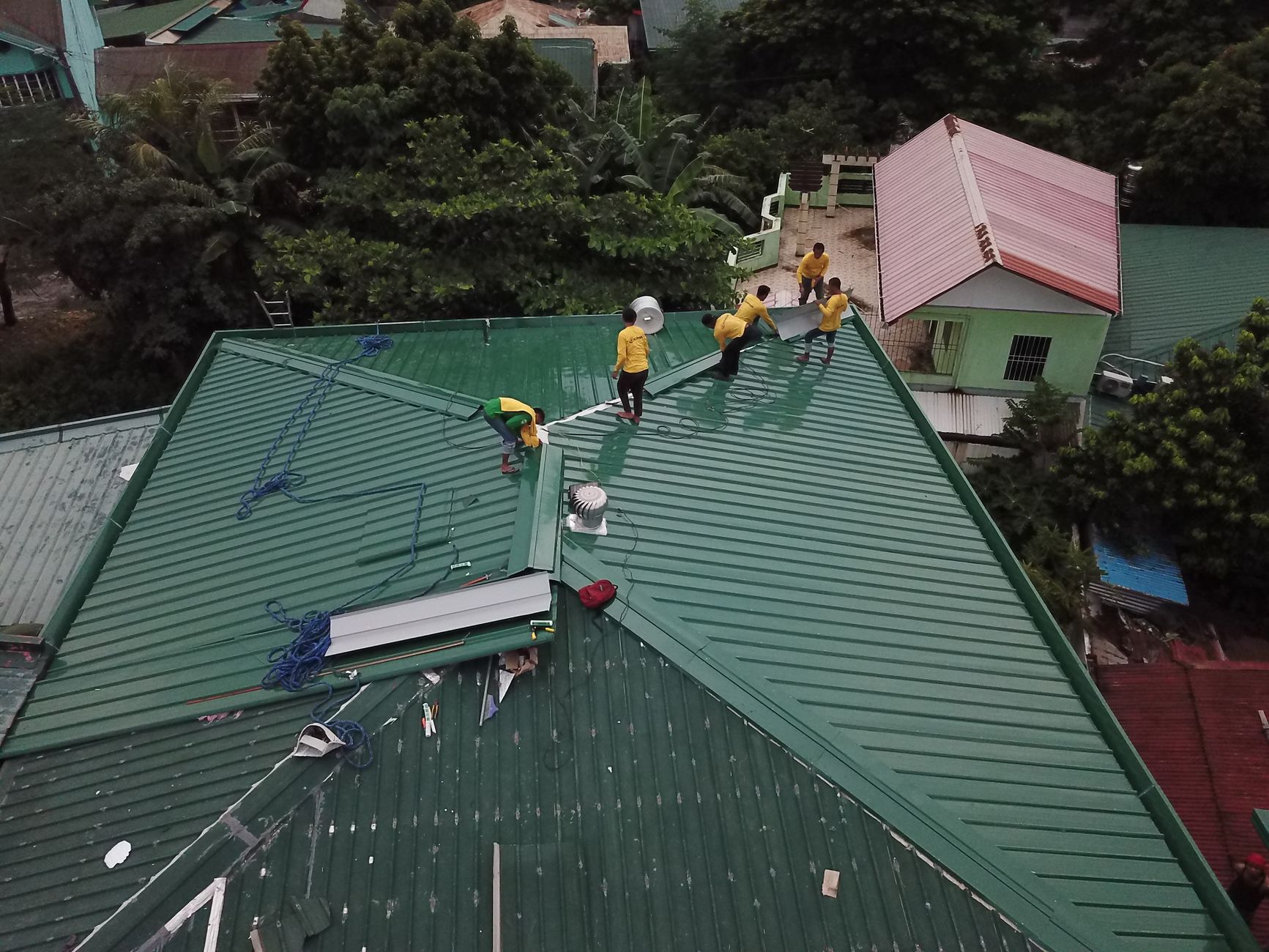 people working on a house roof